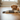 Puppy lying on a wooden floor with a toy resembling a bear