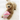 Dog holding the Birthday Cake Dog Toy, shaped like a pink birthday cake with frosting and sprinkles.