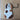 Spotted ceramic dog ornament with brown and white patches, handmade and festive.