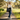 Black tote bag with 'Coffee. Walk. Repeat.' text and paw prints on a wooden surface.