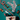 A styled flat-lay of Christmas-themed dog accessories on a teal background, including patterned socks, a red-and-white striped beaded garland, felt dachshund ornaments, candy cane props, pine branches, a small flag, and a cream tote bag with a dachshund illustration.
