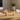 Wooden dog-shaped desk organizer with office supplies on a wooden surface.