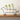 Dog-shaped plant holder with three glass vases containing plants on a wooden surface.