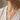 A close-up of a person wearing a delicate silver necklace with a dog-shaped pendant decorated with yellow and white floral details, styled with a cream-colored top.