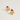 A pair of gold-toned stud earrings shaped like puppy faces wearing red glitter Santa hats with white trim and small pearl-like accents, photographed on a clean off-white background.