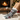 Gray crew socks with a winter dog print and white cuffs, worn on a person's legs sitting on a cozy white knit blanket in front of a warm fireplace and Christmas tree.