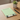 Green notepad with dog illustrations on a wooden table with a plant and pen.