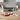An orange silicone mold tray with dog-shaped ice cubes sits on a wooden kitchen counter, with two clear drinking glasses nearby and a blurred kitchen background.
