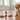 Puppy sitting on a wooden floor with Mutts of Love toy in the shape of a bottle and pizza slice.